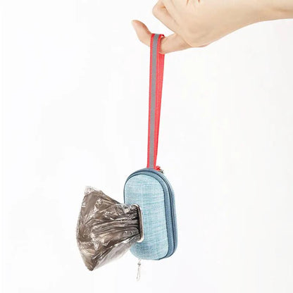 Portable dog poop bag dispenser by AdTec in blue fabric with a red strap, bags visible.