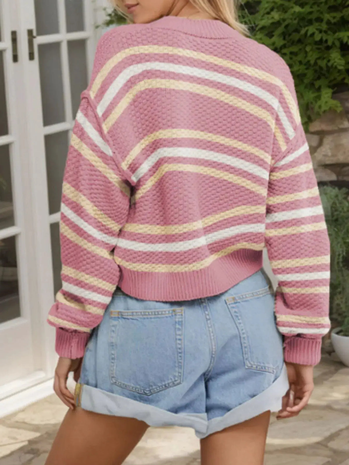 Striped cropped cardigan in pink with cream and yellow stripes; acrylic knit, relaxed fit.
