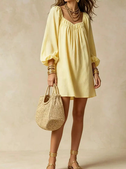 Flowy Balloon Sleeve Mini Dress in pale yellow with gathered neckline; model carries a woven straw bag.