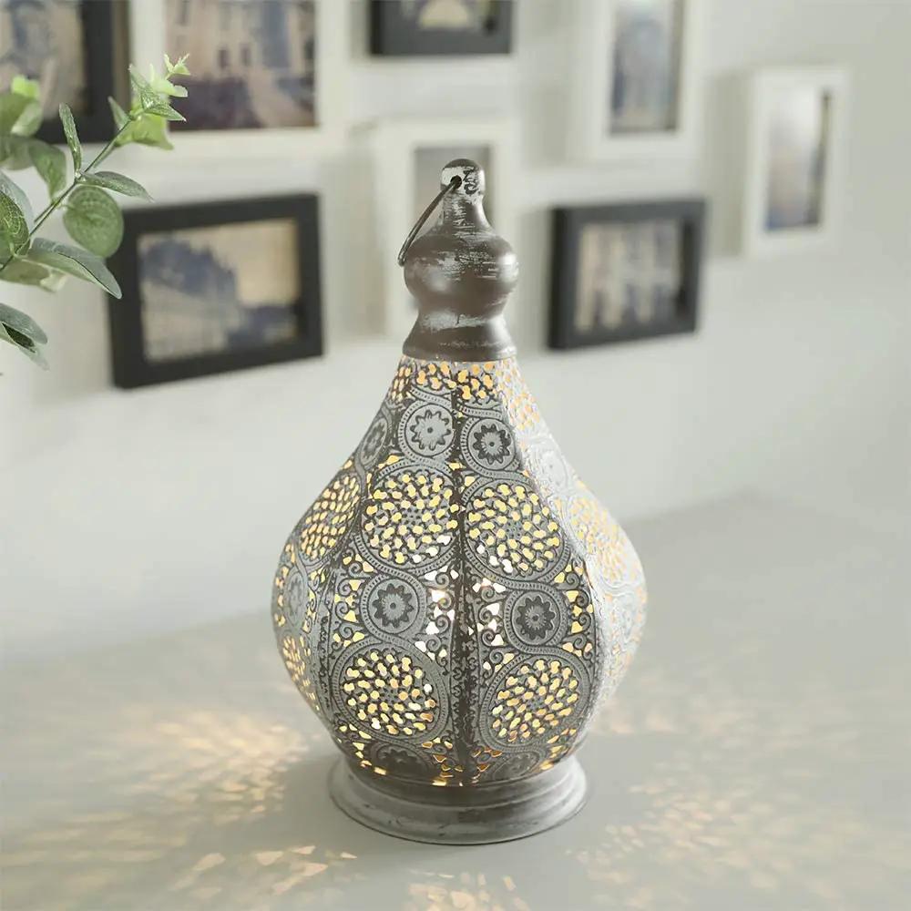 11.5'' tall battery-powered table lamp with ornate gray perforated metal pattern and warm glow