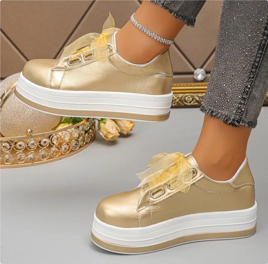 Pair of AdTec women's gold metallic lace-up platform flats with rounded toe and thick white sole