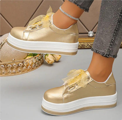 Pair of AdTec women's gold metallic lace-up platform flats with rounded toe and thick white sole