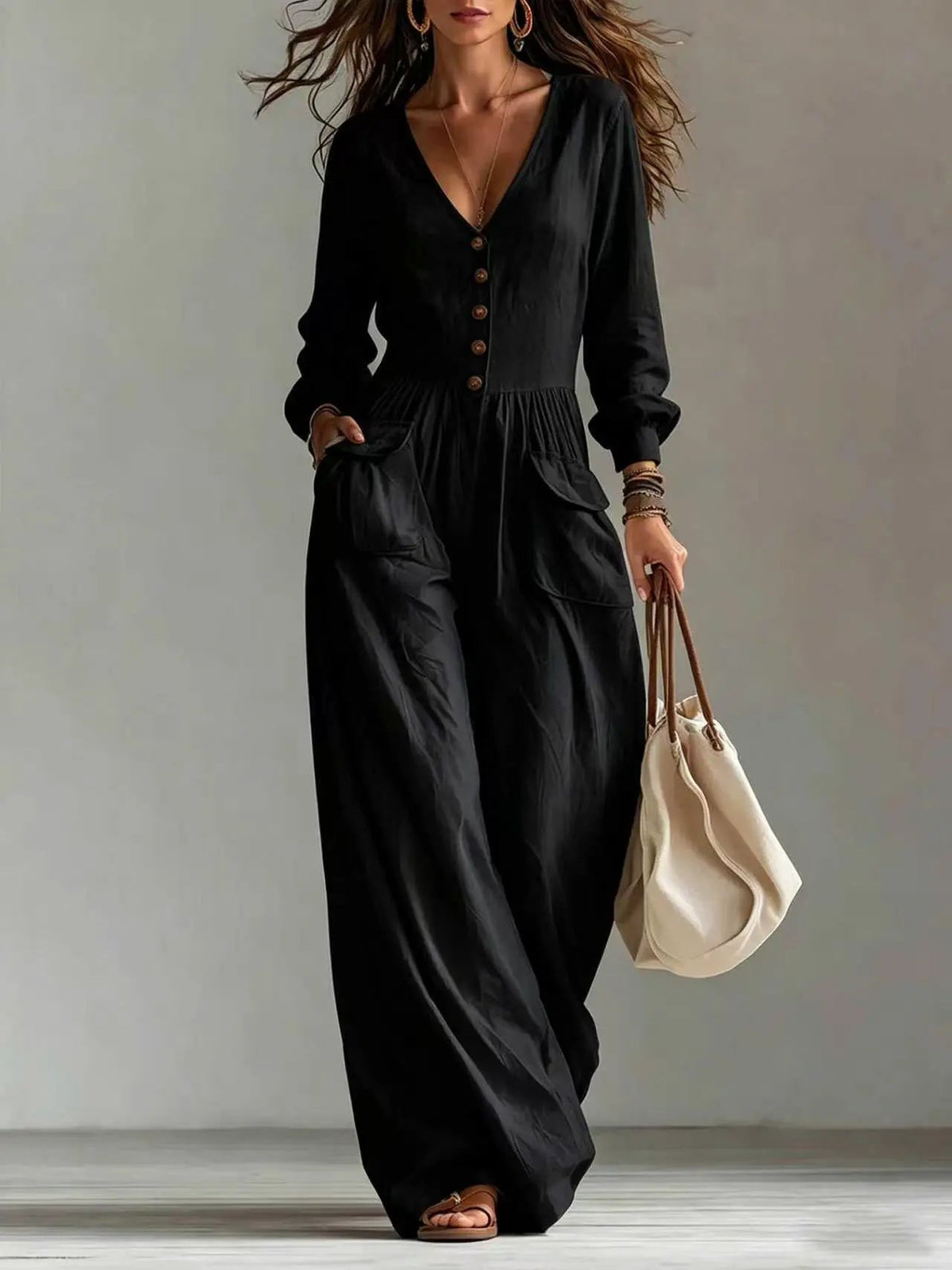 AdTec women's black V-neck long-sleeve jumpsuit with pockets and front buttons.