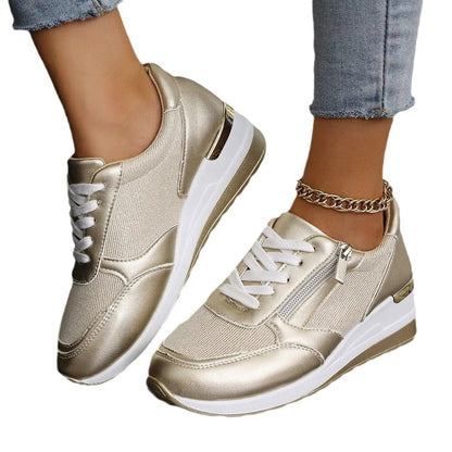 Pair of AdTec women's metallic gold lace-up sneakers with side zipper and thick white sole