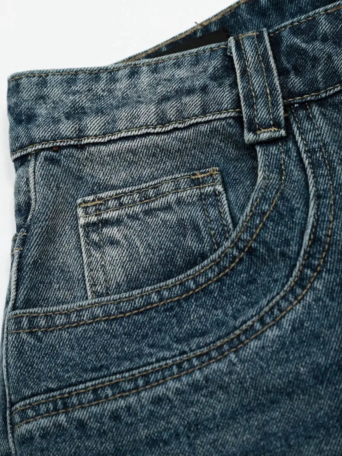 Men's relaxed wide-leg denim shorts in blue washed cotton; close-up of belt loop and pocket stitching.