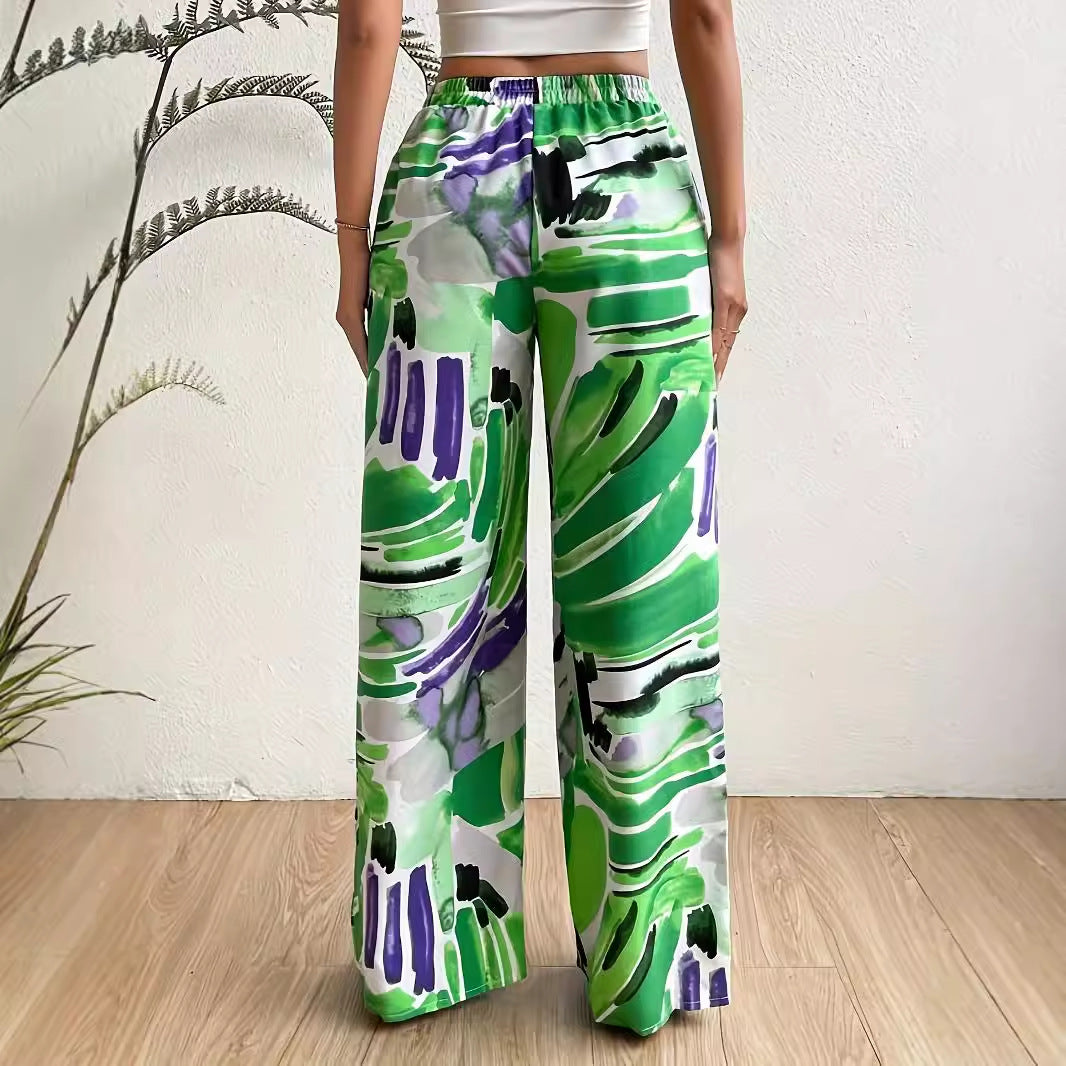 Elastic waist wide-leg trousers by eprolo in a green, purple, black abstract print.