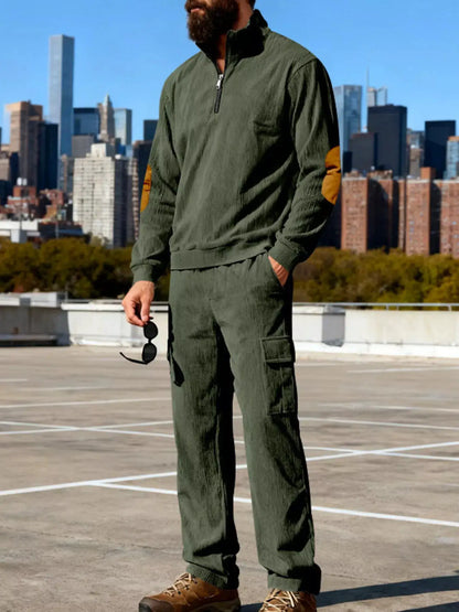 Plus-size mens olive green matching long-sleeve top and cargo pants set on a rooftop with city skyline