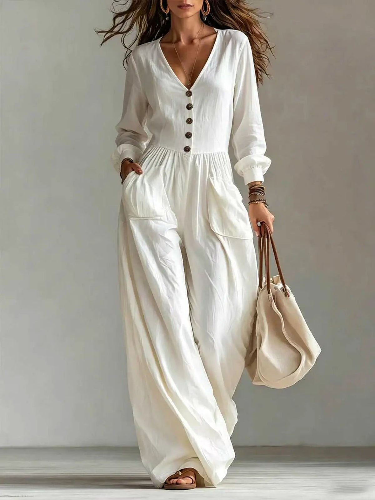 Womens white V-neck long-sleeve jumpsuit with pockets and front button placket; wide-leg fit.