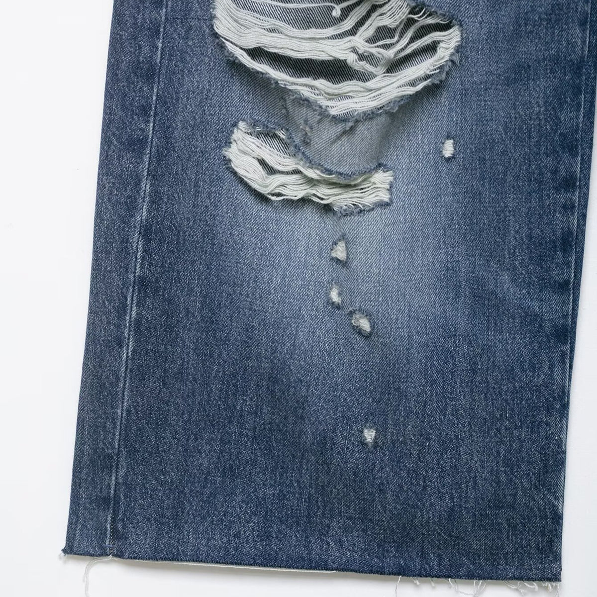 Denim shorts with broken-hole distressed detail, mid-rise navy blue, frayed hems.