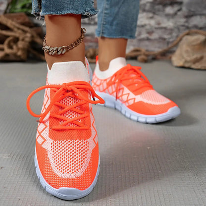 Pair of women's orange colorblock plaid lace-up Flyknit sneakers with breathable mesh and white sole
