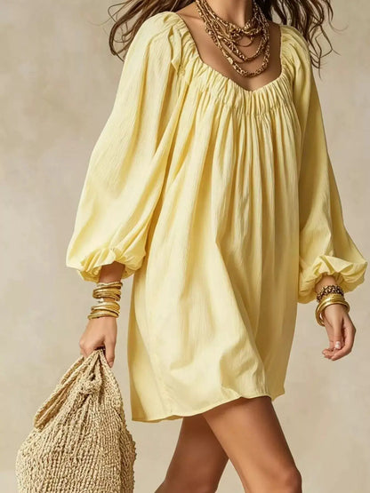 Flowy balloon-sleeve mini dress in pale yellow with a gathered neckline.