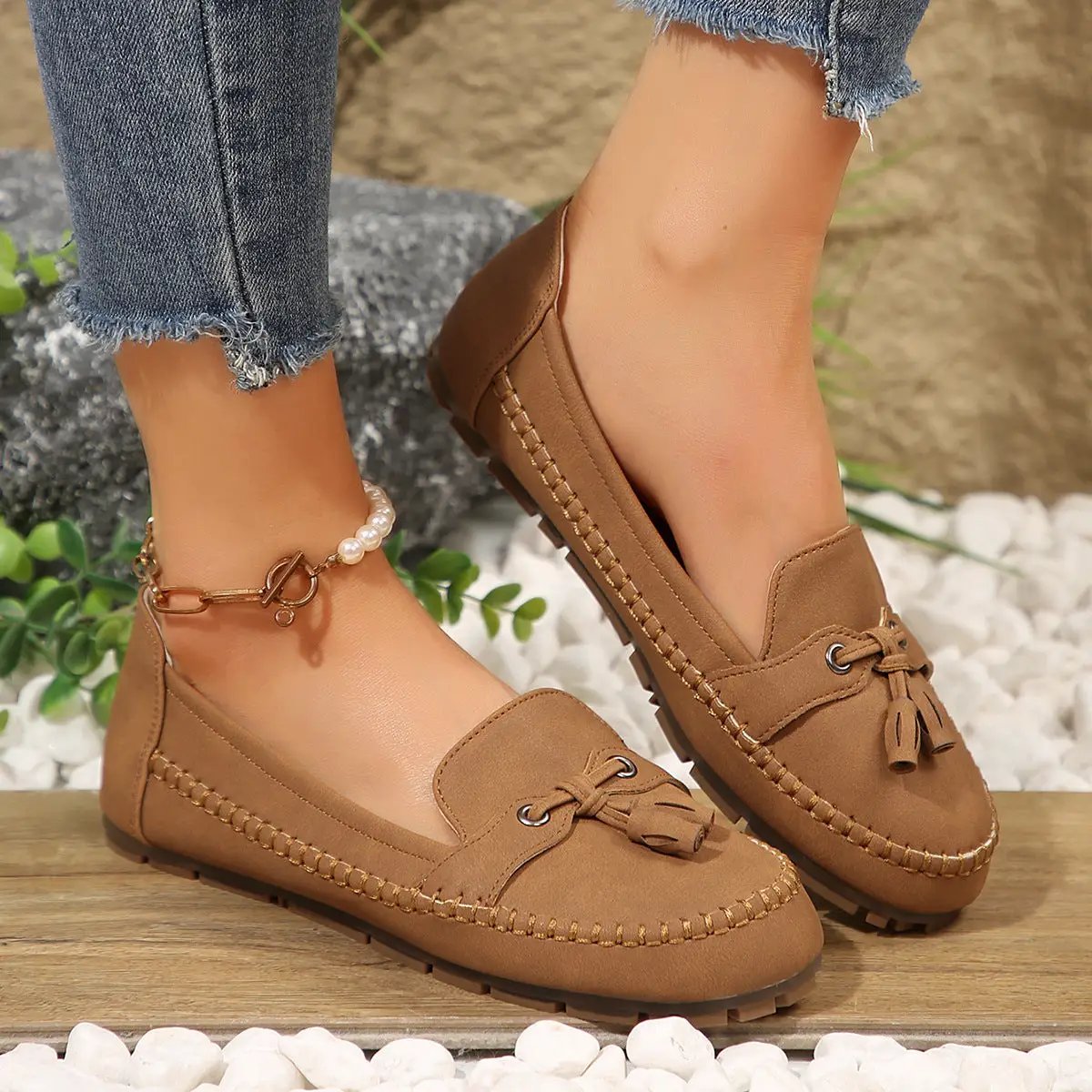 Pair of women's tan tassel loafers with stitched detailing and non-slip sole