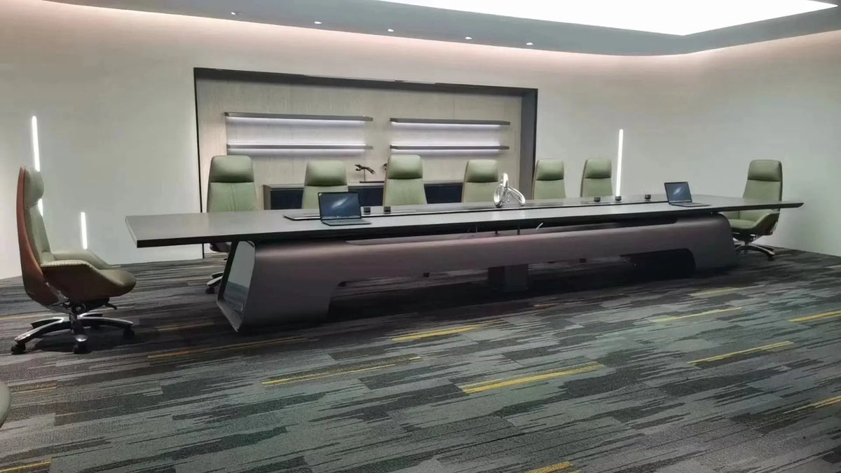 Large executive conference table in a modern boardroom with a dark top and green ergonomic chairs