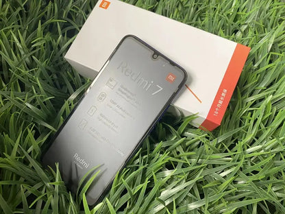 Xiaomi Redmi 7 smartphone with gray body displayed beside its box