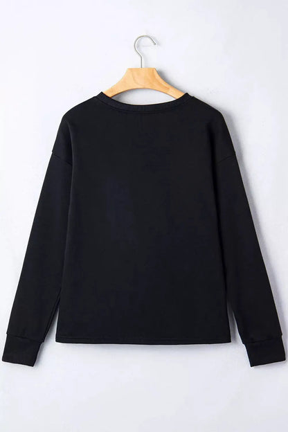 Black round-neck long-sleeve T-shirt on a wooden hanger, plain back view.