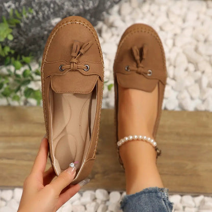 Women's tan brown tassel loafers, a pair with round toe and moc-style stitching