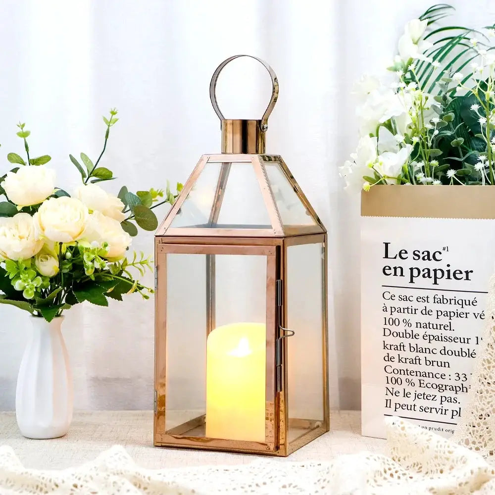 16-inch high decorative lantern with copper finish, glass panels, and a lit candle inside