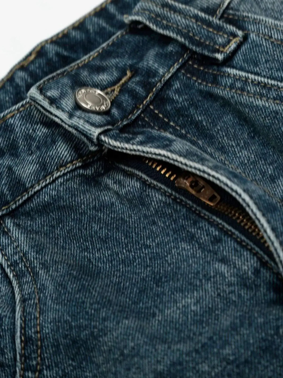 Men's Relaxed Wide Leg Denim Shorts in blue washed cotton; close-up of metal button and zipper on denim fabric.