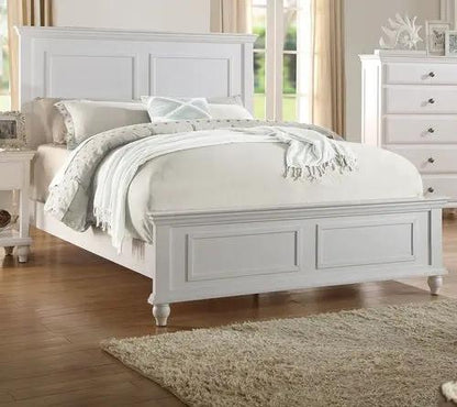 White queen-size bed with high panel headboard in a bright bedroom.