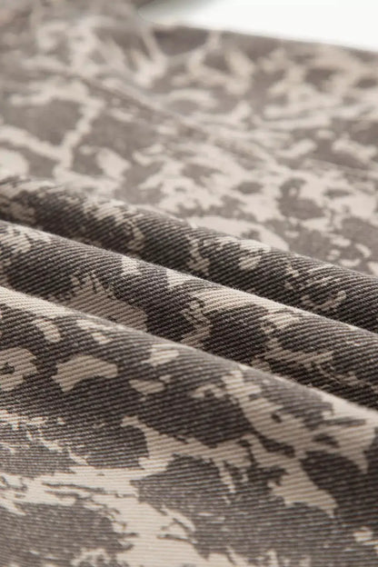Long-sleeve denim jacket with abstract gray-beige camo print and raw hem.