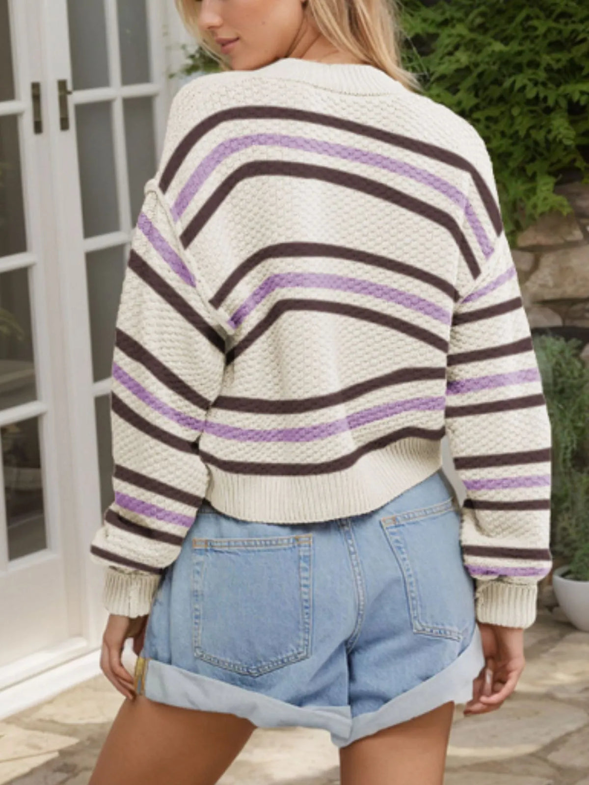 Striped button-up cropped cardigan in cream with purple and brown stripes; acrylic knit, relaxed fit.