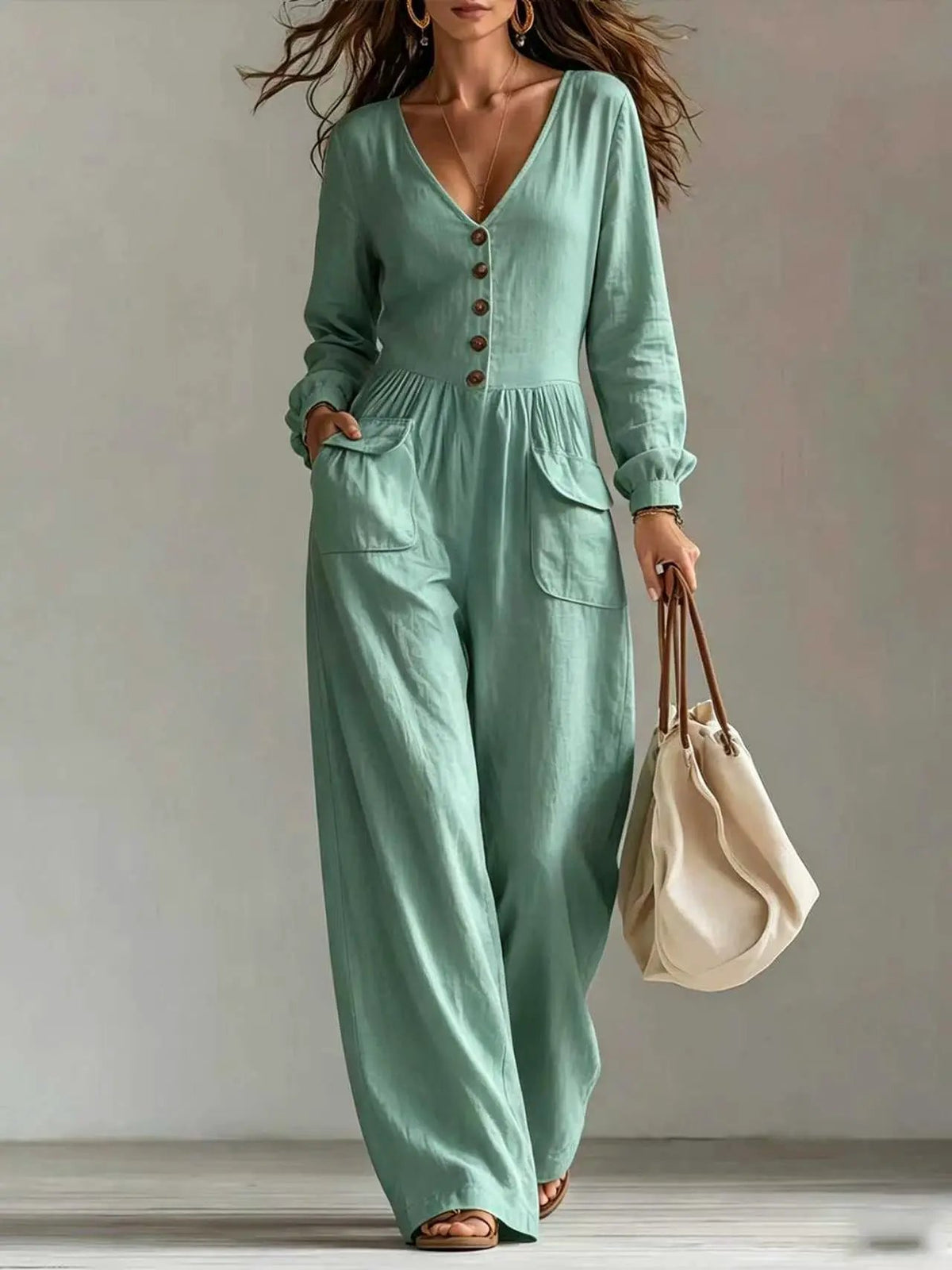 Jumpsuit by AdTec in mint green with V-neck, button front, long sleeves, patch pockets and wide legs.