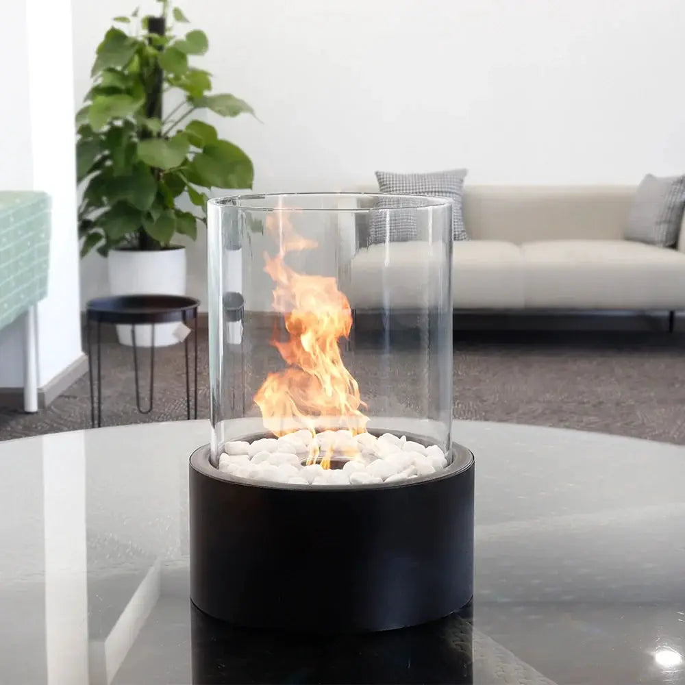 Extra Large Portable Tabletop Fire Bowl, bio-ethanol ventless, with clear glass cylinder and white stones on a black base