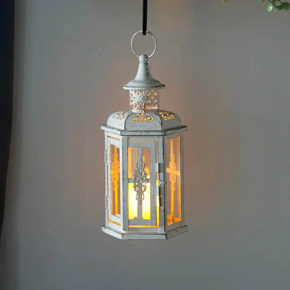 10 inch high vintage-style hanging lantern candleholder, distressed white metal with glass panels and warm candlelight