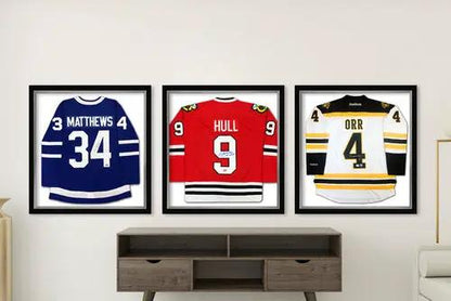 Three framed hockey jerseys: Matthews 34 blue Maple Leafs, Hull 9 red Blackhawks, Orr 4 white Oilers.