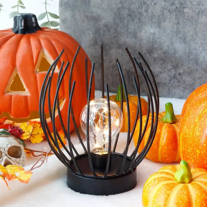 7-inch tall battery-powered table lamp with black wire globe frame and clear bulb
