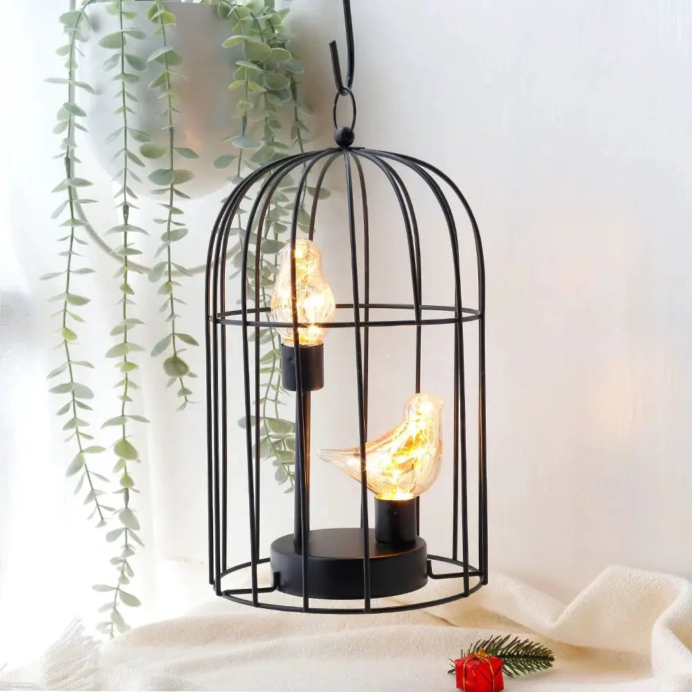 12-inch tall battery-operated birdcage lamp with a black metal cage and two warm, bird-shaped bulbs inside